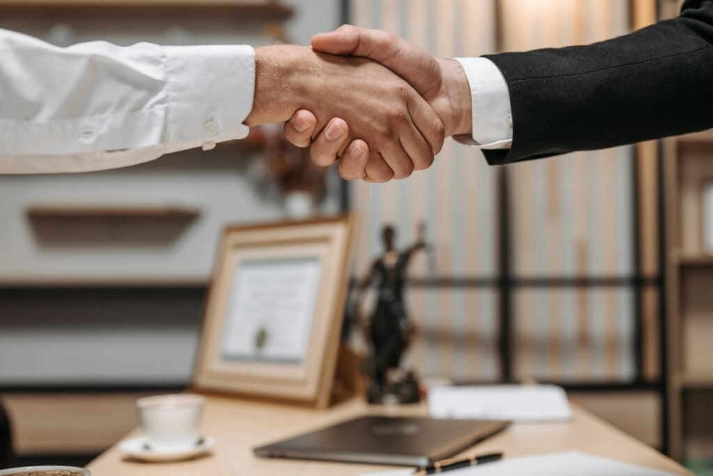 pexels-photo-8112172-8112172 Close-up of a handshake between two professionals in a modern office setting, emphasizing partnership and agreement.